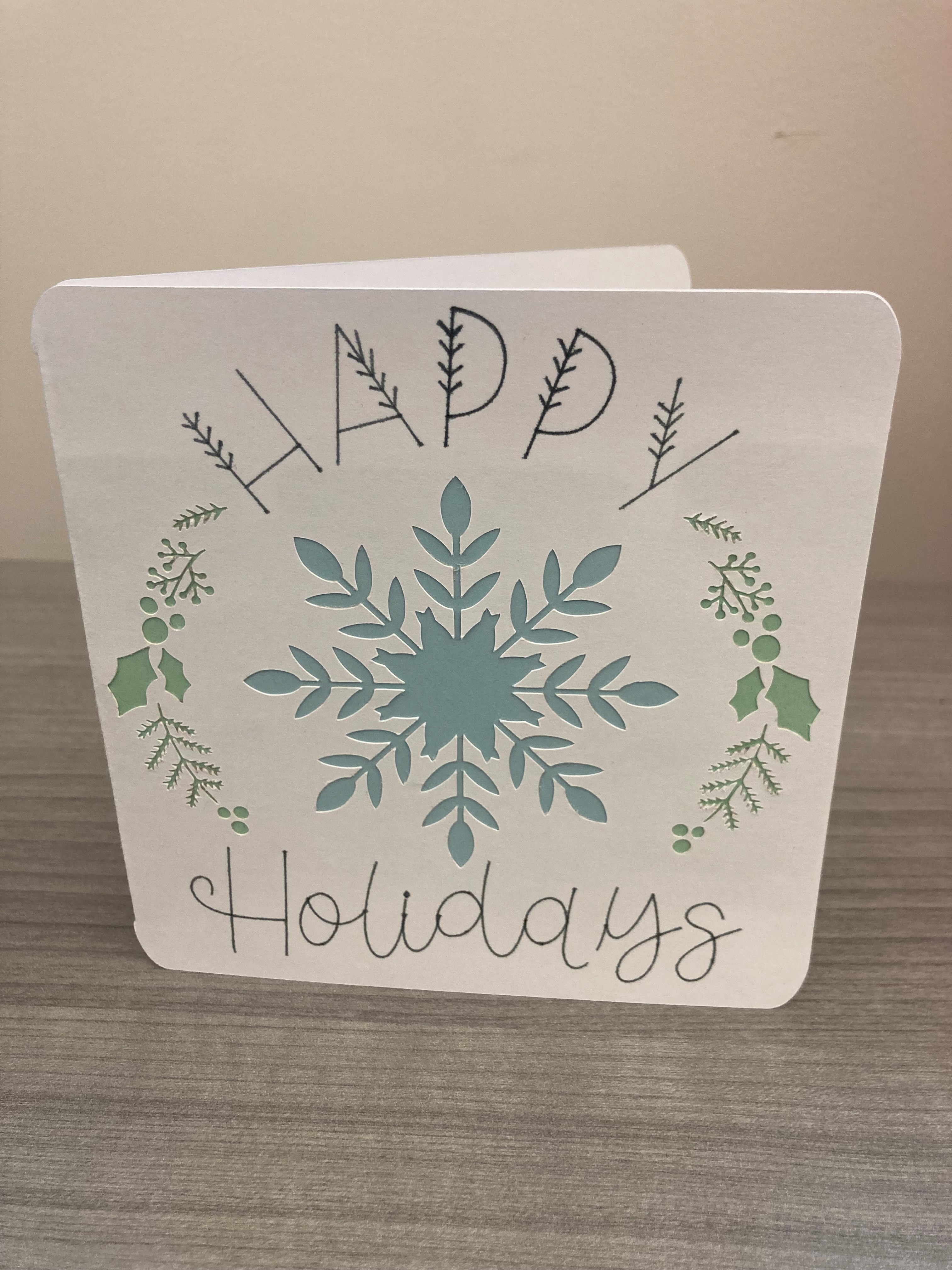 paper card; text "Happy Holidays"; snowflake