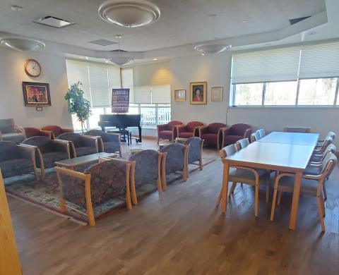 medium sized room set up with upholstered chairs and two tables