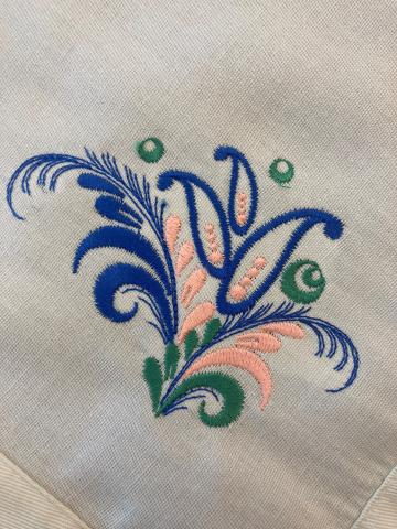 Embroidered floral design on a fabric napkin.