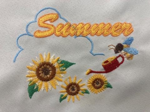 Embroidered napkin with sunflowers, a bee, and the word "Summer"