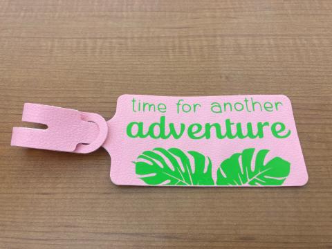 Faux leather luggage tag that says "Time for another adventure"