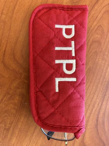 Potholder sewn into a cloth glasses case and embroidered with "PTPL"