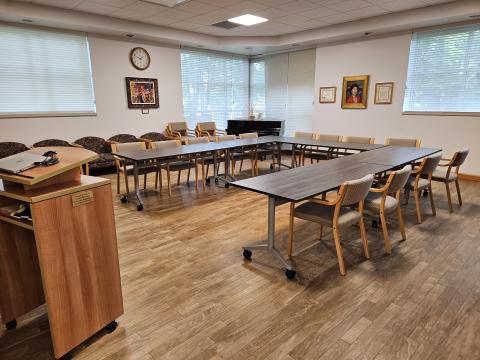 medium sized room set up with upholstered chairs and five tables