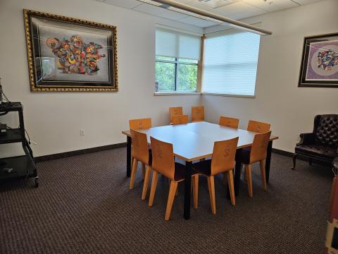 small conference room setup with large table and 8 wooden chairs