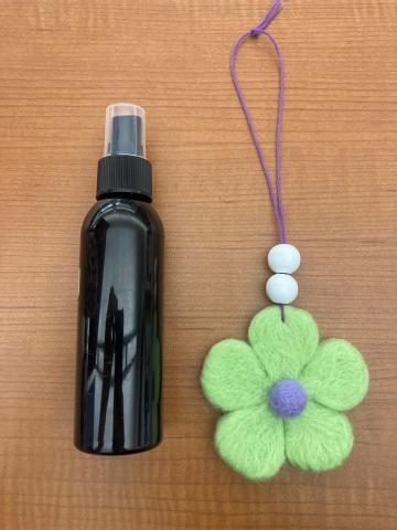 Wool shaped into a flower next to a spray bottle
