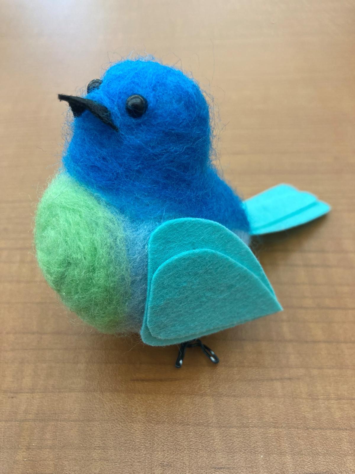 3 dimensional bird made of blue and green wool and felt.