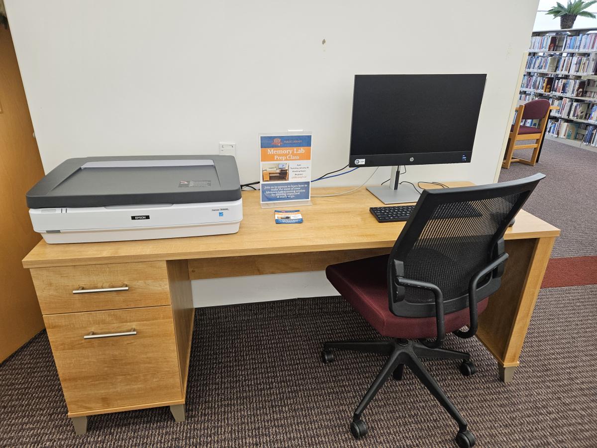 Photo of a wooden desk, computer, and a flatbed scanner