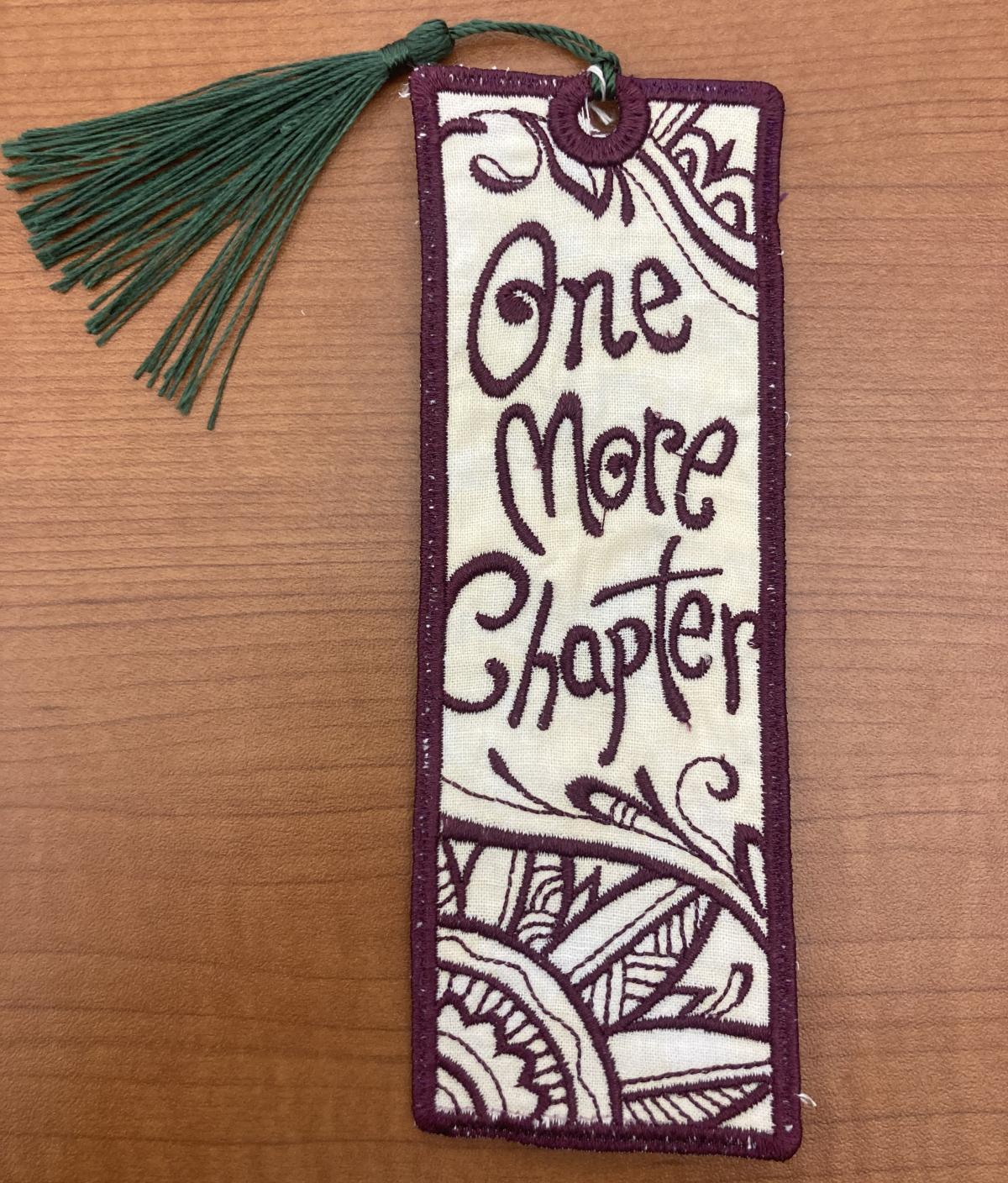 Fabric bookmark embroidered with "One More Chapter"